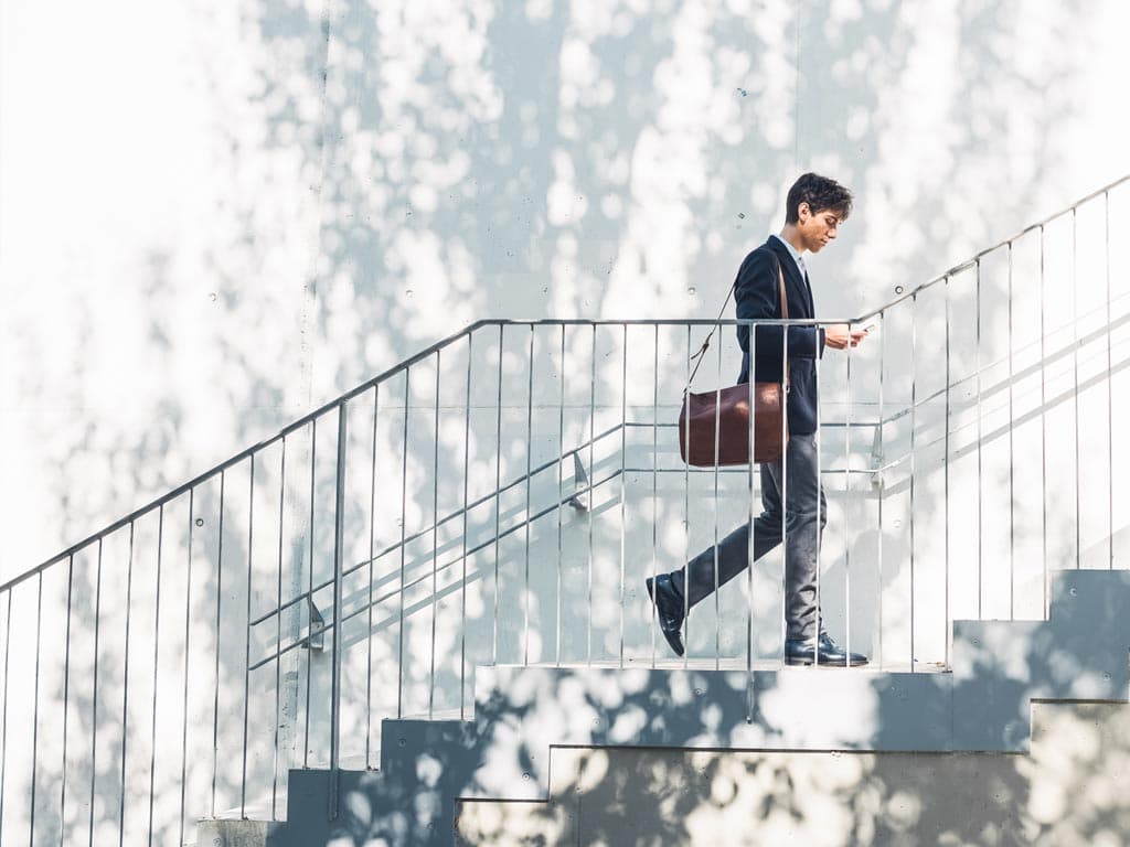 Muškarac u odijelu samouvjereno se penje uz stepenice, odišući profesionalnošću i odlučnošću