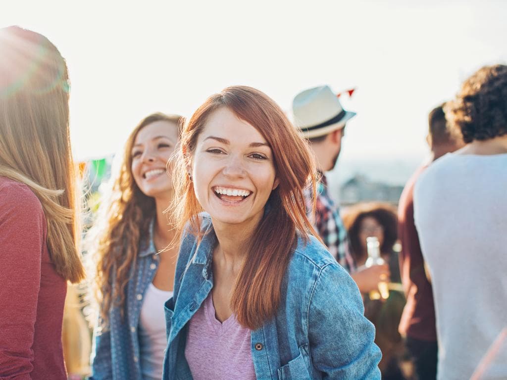 Raznolika skupina ljudi smiješi se i uživa u međusobnom društvu u živahnom okruženju